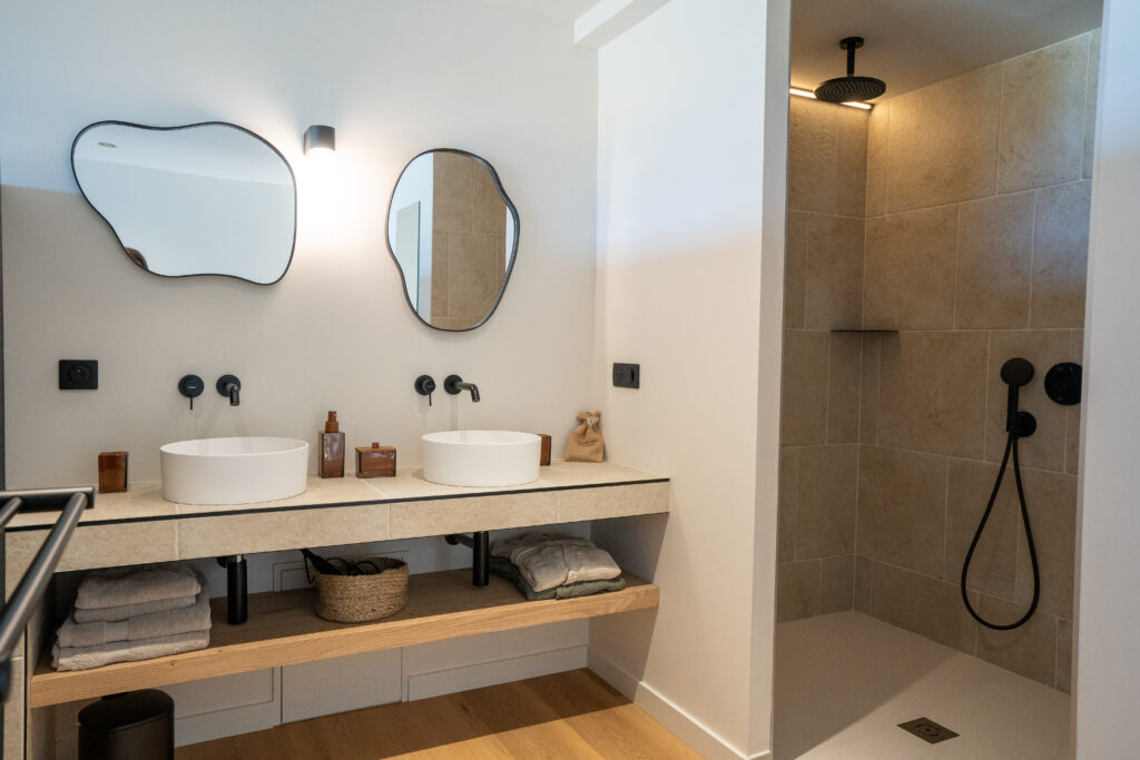 Salle de bain double vasque et douche à l'italienne dans l'une des chambres des Hauts du Fort
