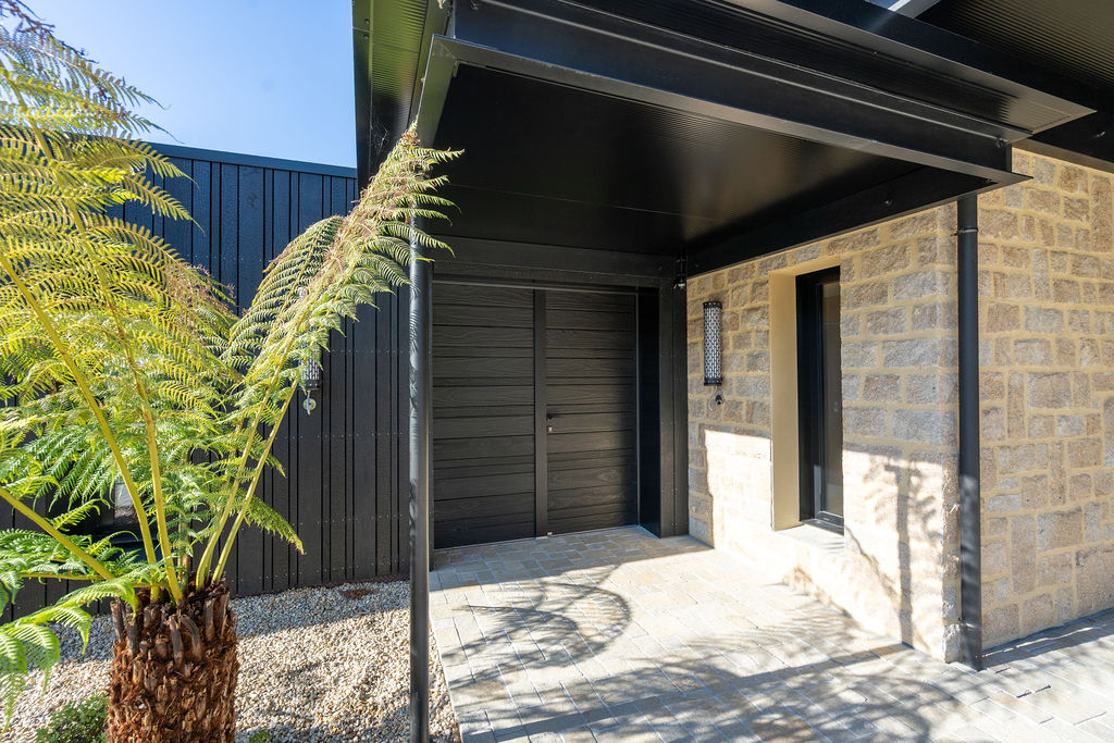 Entrée principale de la maison avec fougères et carport