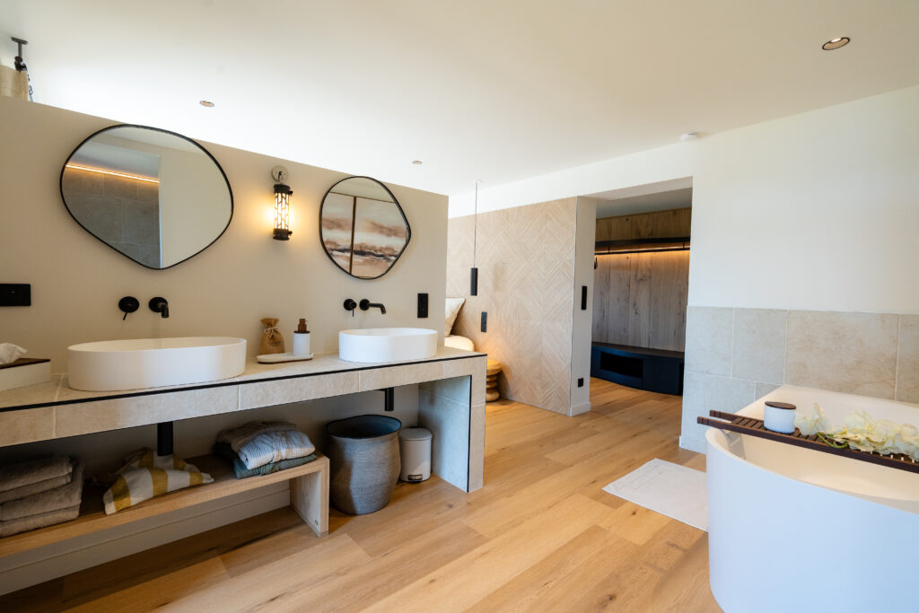 Salle de bain avec double vasques et baignoire dans une chambre des Hauts du Fort